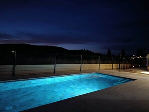 A rectangular swimming pool with a dark surrounding area and a fence. - Villa de Judith Roaix Provence (Roaix)