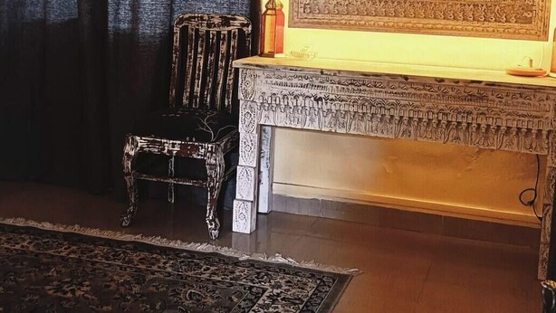 Une pièce dotée d’un grand miroir, d’un tapis à motifs, d’un banc et d’un appareil de climatisation.