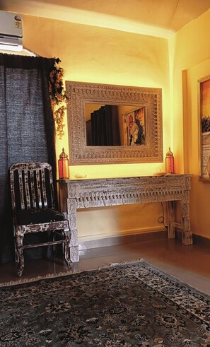 A room with a large ornate mirror, a wooden bench, and a patterned rug. - Hill view apartment 2 (Ashwem)