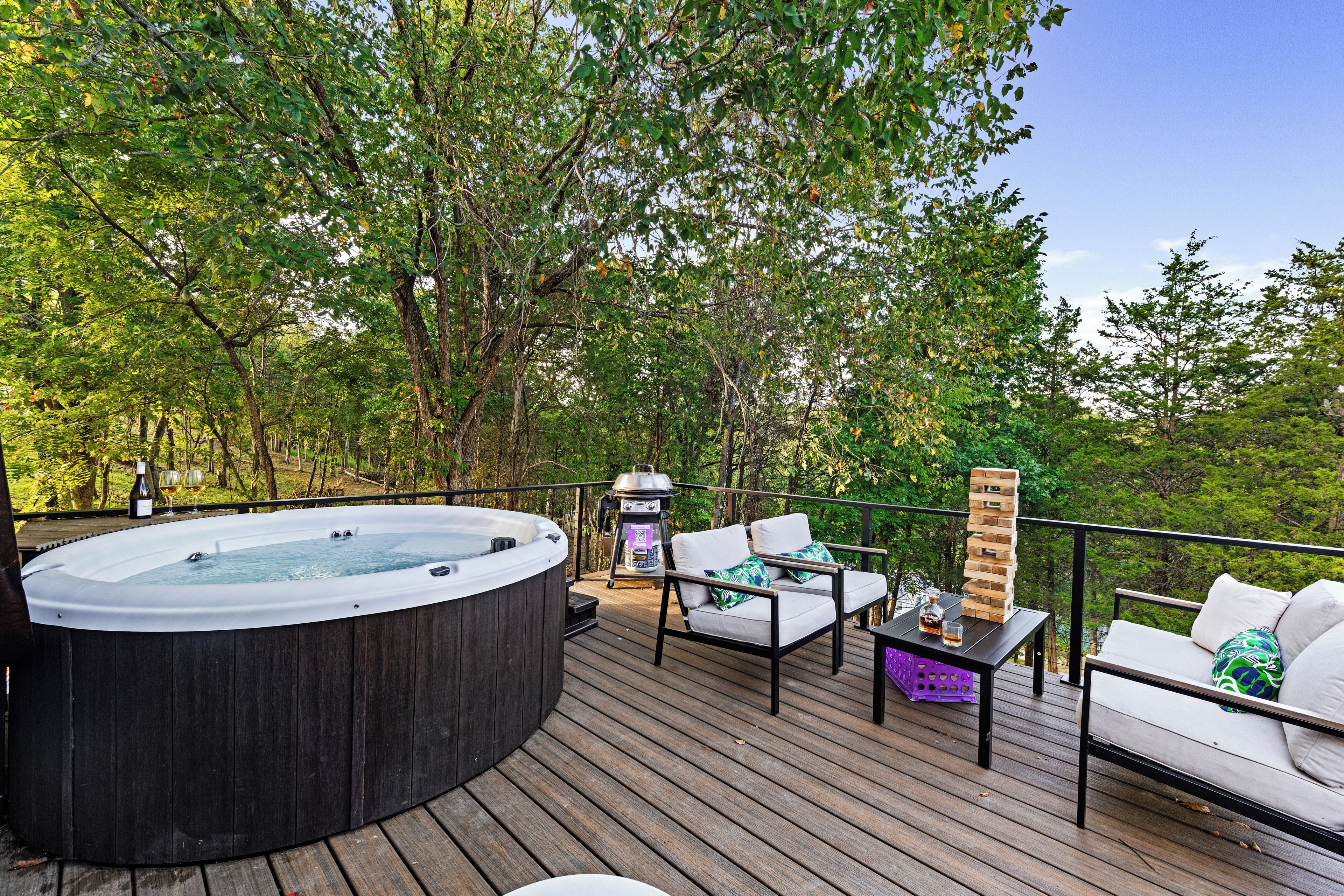 Une terrasse dotée d’un jacuzzi, d’un espace salon extérieur et d’un barbecue.