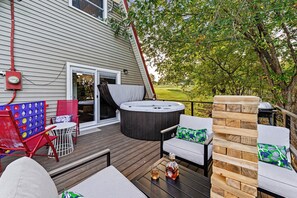 Une terrasse dotée de mobilier d’extérieur, d’un jacuzzi et d’un barbecue.