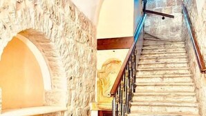 A stone staircase with a metal railing leading to a higher level.