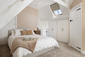Ein Schlafzimmer mit Bett, Nachttisch und Kleiderschrank.