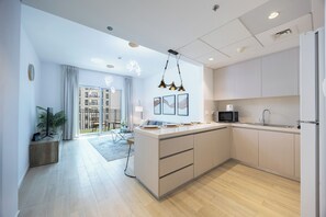 A modern kitchen with a central island, a microwave, and a sink. - Bloomfields 2BR in Waters Edge 9  (Abu Dhabi)