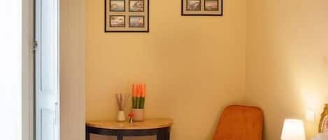 Habitación de hotel con cama, una silla, una mesa con toallas y decoración en la pared.