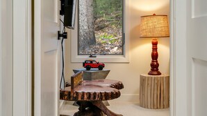 Ein Holztisch mit einem 'PARADISE' Schild, einer Lampe und einem Spielzeugauto auf einem Sockel.