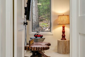 A wooden dining table with a 'PARADISE' sign, a lamp, and a toy car on a stand. - Renovated Modern Chalet in Mad River Valley (Warren)