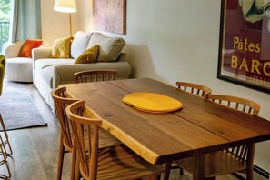 Ein Essbereich mit einem Holztisch, Stühlen und einer gelben Tischdecke.