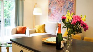 A room with a dining table, a bottle of wine, and a vase of flowers. - 1BR, 2nd Floor Condo at Sugarbush (Warren)