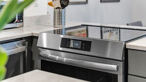 Eine Küche mit Edelstahlbackofen, Geschirrspüler und Kaffeemaschine.