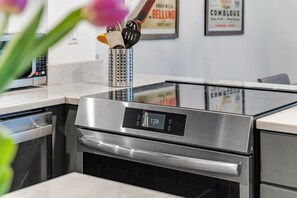 A kitchen with a stainless steel oven, a dishwasher, and a coffee machine. - Mad River Valley Modern 3 bedroom & 2 bath Condo; Convenient Location (Warren)
