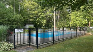 Ein umzäunter Swimmingpool mit einem Schild, das darauf hinweist, dass er nur für Bewohner und Gäste bestimmt ist.