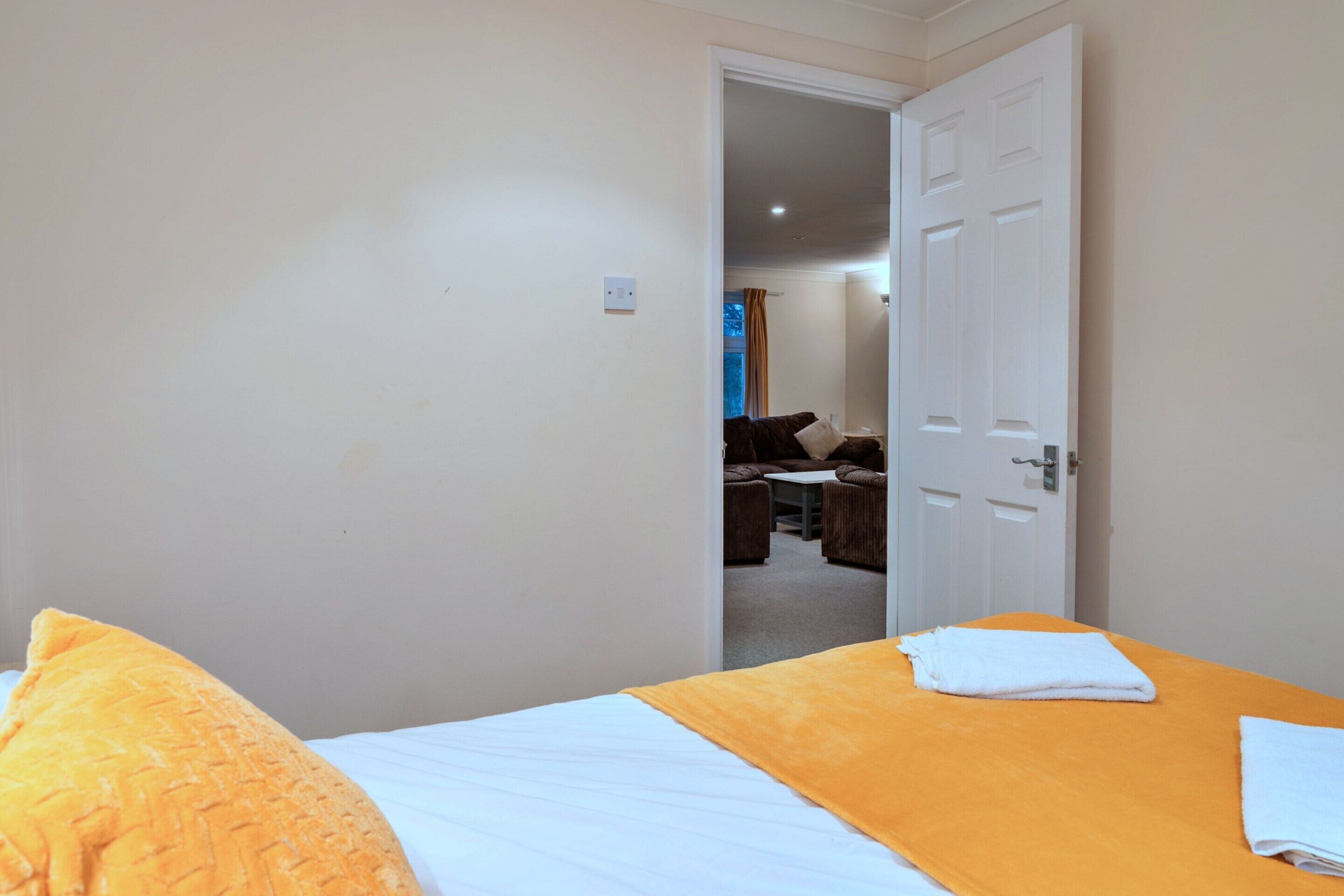A hotel room with a bed, a table, and a chair.