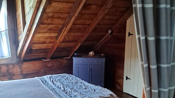 Huone, jossa on sänky, vaatekaappi ja ikkuna.