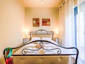 Un lit avec une tête de lit, deux tables de chevet et des œuvres d’art accrochées au mur.