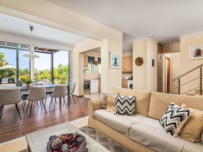Una sala de estar moderna con sofá, comedor y cocina.