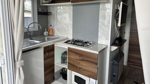 A compact kitchenette with a gas stove, sink, and a microwave. - RBR 1463  - Beach Resort Kamperland by Interhome (Kamperland)