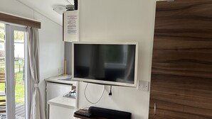 A modern kitchen with a flat-screen TV, a built-in oven, and a wooden cabinet. - RBR 1463  - Beach Resort Kamperland by Interhome (Kamperland)