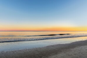 Una playa con mar tranquilo y cielo despejado.