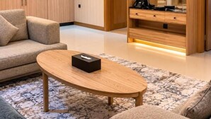 Una sala de estar moderna con sofá, mesa de centro y mueble para televisión.