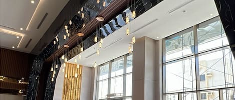 A spacious lobby with seating areas, large windows, and a modern design.