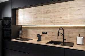 A modern kitchen with black appliances, a wooden backsplash, and a black faucet. - Villa Luce
Wonderful 3-bedroom house with heated pool in charming Podstrana (Podstrana)