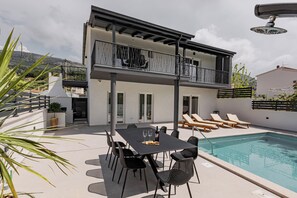 A modern two-story building with a pool, outdoor seating, and a balcony. - Villa Luce
Wonderful 3-bedroom house with heated pool in charming Podstrana (Podstrana)
