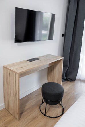 A modern room with a wooden desk, a black ottoman, and a mounted flat-screen TV. - Villa Luce
Wonderful 3-bedroom house with heated pool in charming Podstrana (Podstrana)