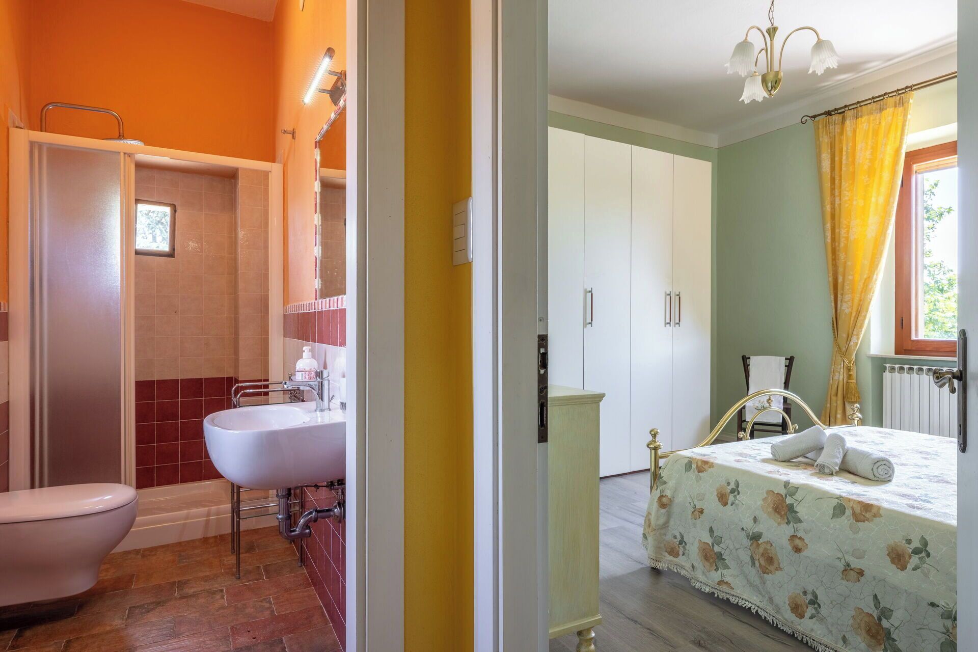 Un baño con bañera, inodoro y lavabo, y un dormitorio con cama y ventana.