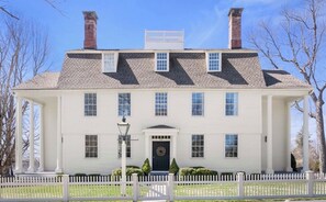 A two-story white building with a symmetrical facade, a central entrance with a door, and a white picket fence in front. - The 1775 Colonel Benjamin Tallmadge House on the Litchfield Green (Litchfield)