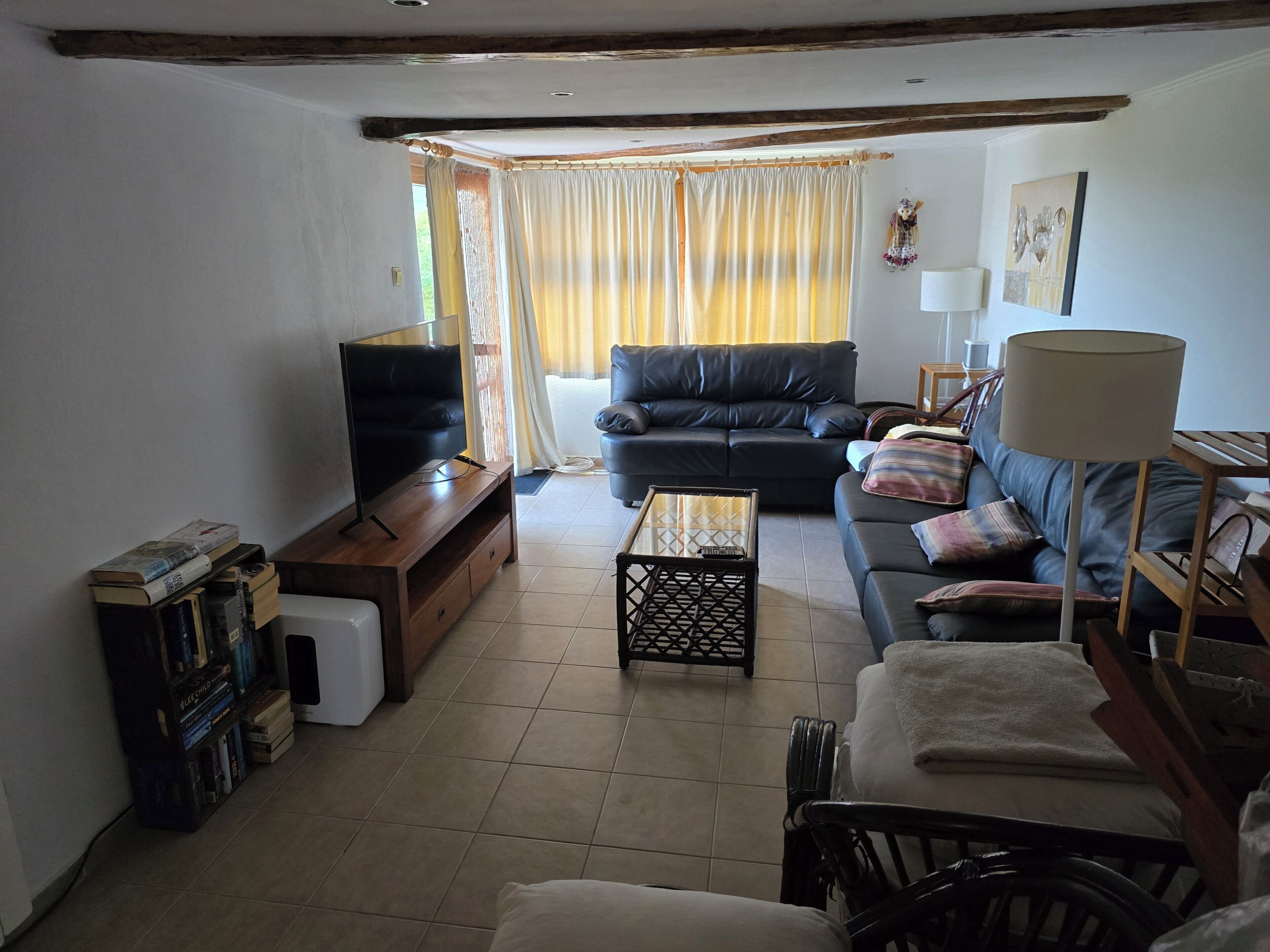 A living room with a television, sofa, and a small table.