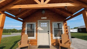 A log cabin with a porch, two windows, a door, and a sign reading 'LIFE at Lake.' - Tranquil Cabin In Charming Bean Station Tn on Cherokee Lake With Boat Ramp (Bean Station)