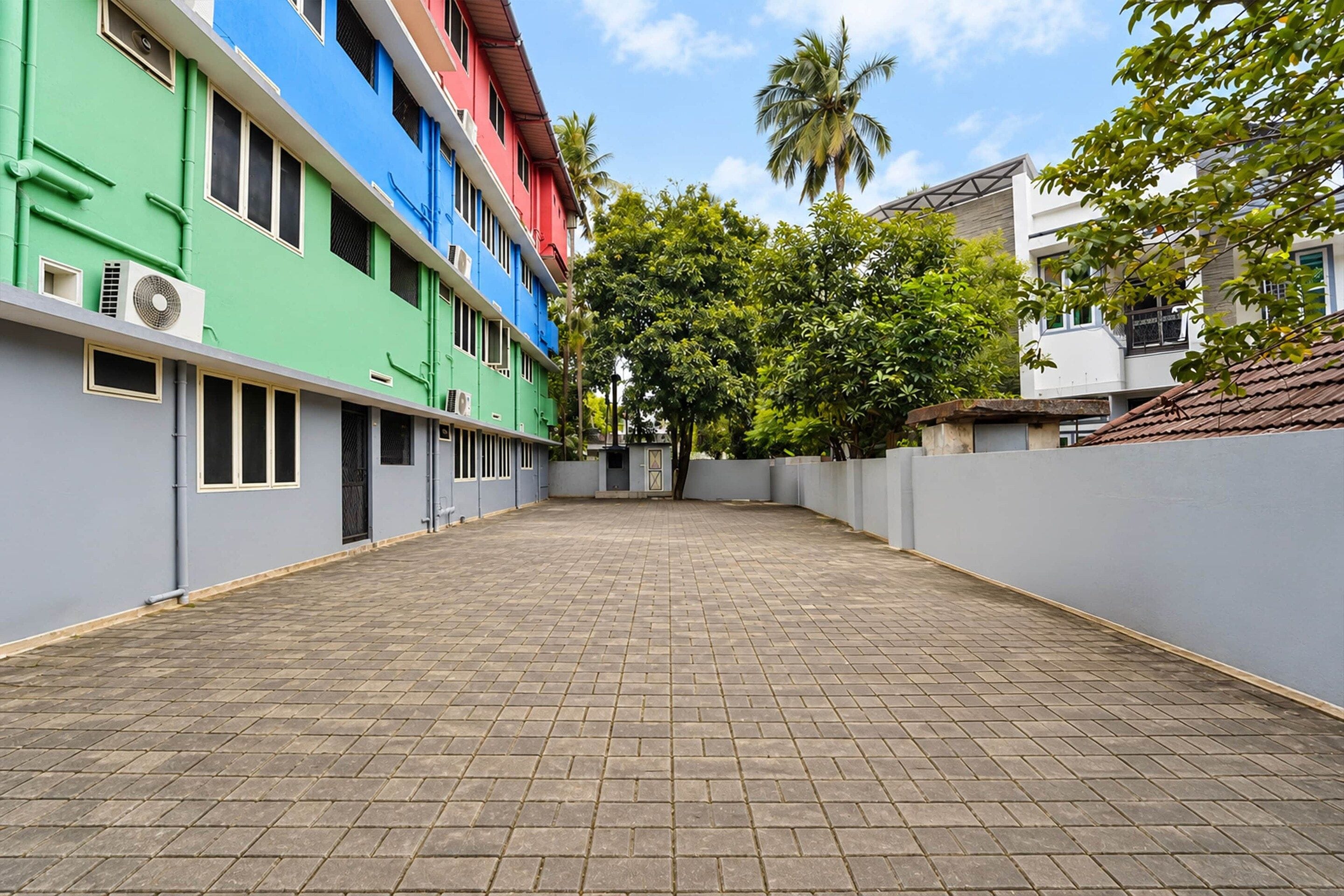 Un patio con un sendero adoquinado rodeado de edificios con fachadas coloridas.