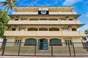 A multi-story hotel building with a sign indicating it is serviced by OYO.
