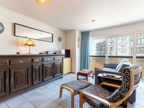 Ein modernes Wohnzimmer mit einer Couch, einem Couchtisch, einem Fernseher und einem Schrank.