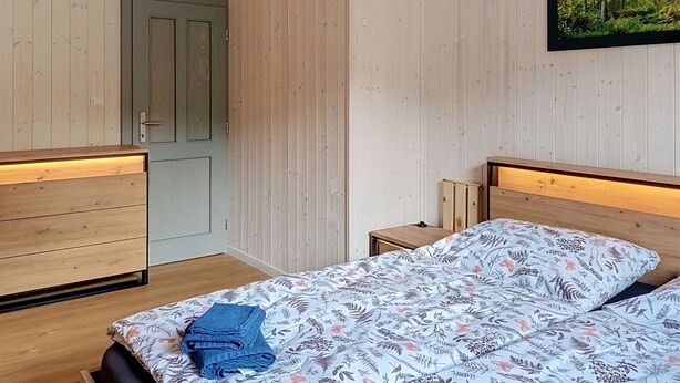 Huone, jossa on sänky, työpöytä ja ovi.