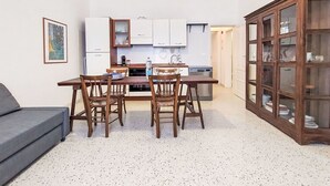 Um espaço compacto com área de refeições, cozinha compacta e um armário com portas de vidro.