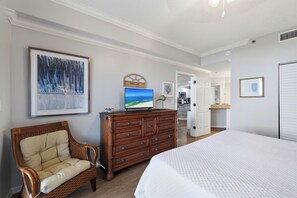 Ein Schlafzimmer mit Bett, Schminktisch, Stuhl und einem Kunstwerk an der Wand.