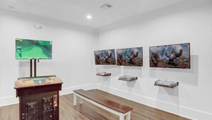 Een galerij met schilderijen, een televisie en een bank.