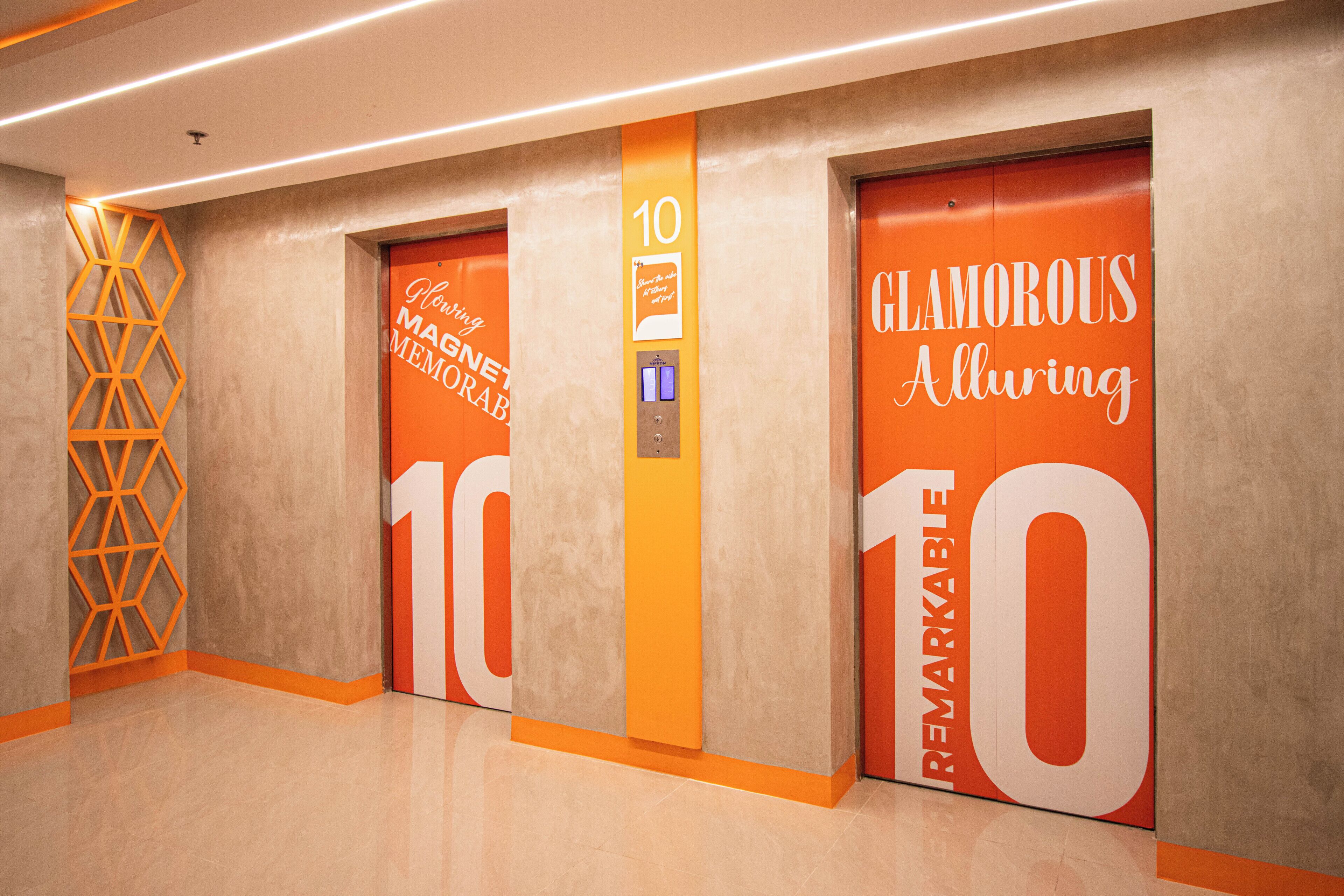 Un ascensor moderno con señalización llamativa, que incluye las palabras 'Glamorous Alluring' y 'Remarkable' en las puertas.