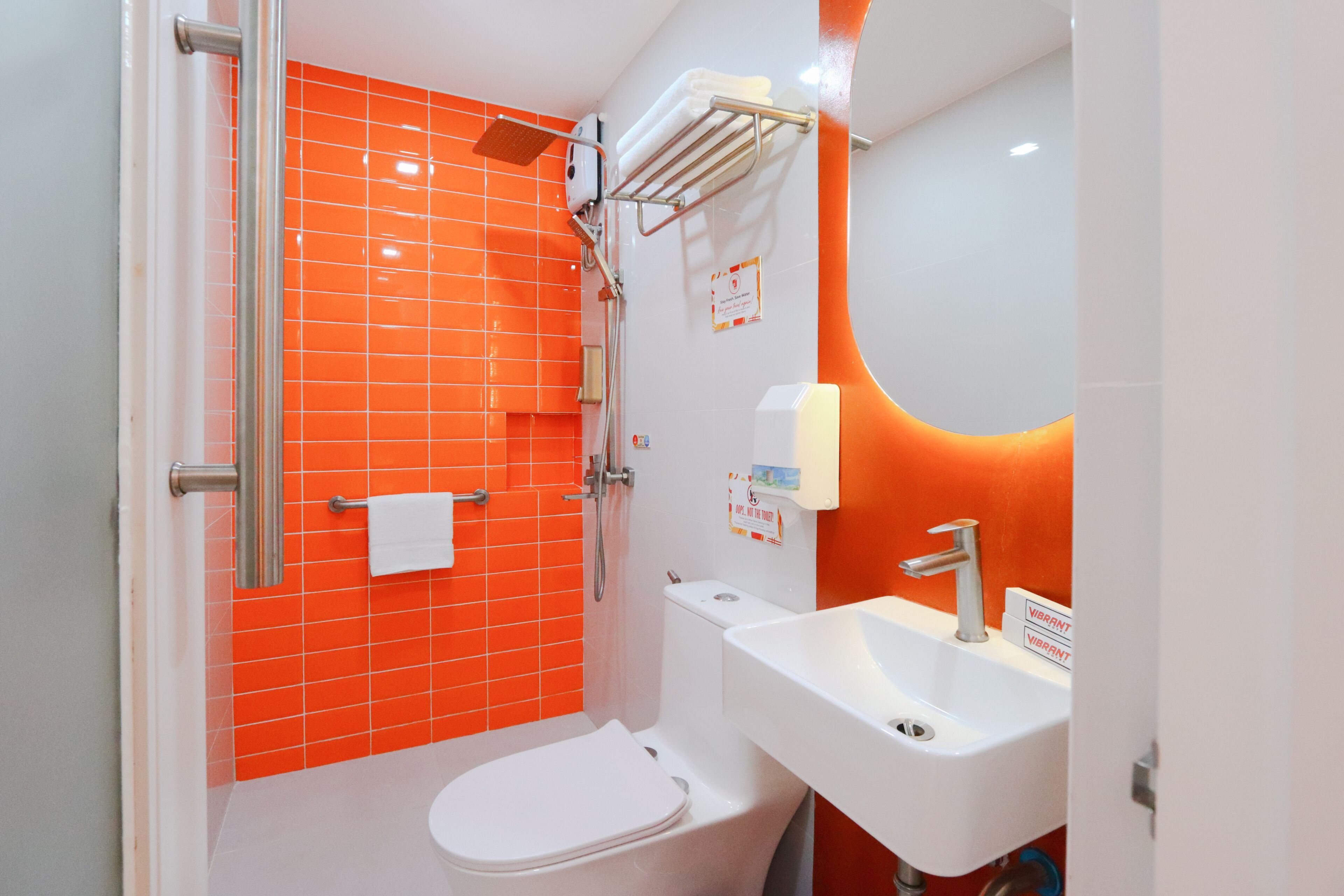 A bathroom with a white toilet, a shower with a glass door, and a sink with a mirror.