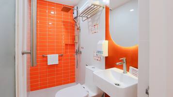 A bathroom with a white toilet, a shower with a glass door, and a sink with a mirror.