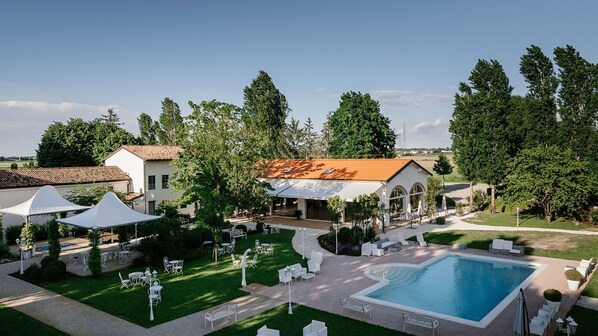 A resort with a swimming pool, outdoor seating, and a covered area.