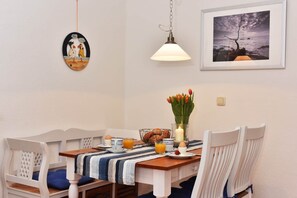 Un comedor con una mesa dispuesta para el desayuno, una lámpara colgante y obras de arte en las paredes.