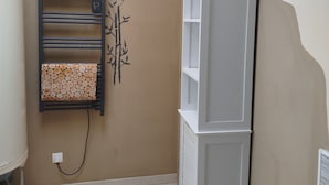 A room with a wall-mounted heater, a white cabinet, and a wall-mounted lamp. - L'Erable du Perche (Tourouvre au Perche)