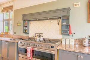Una cocina con estufa a gas, horno y salpicadero de azulejos.