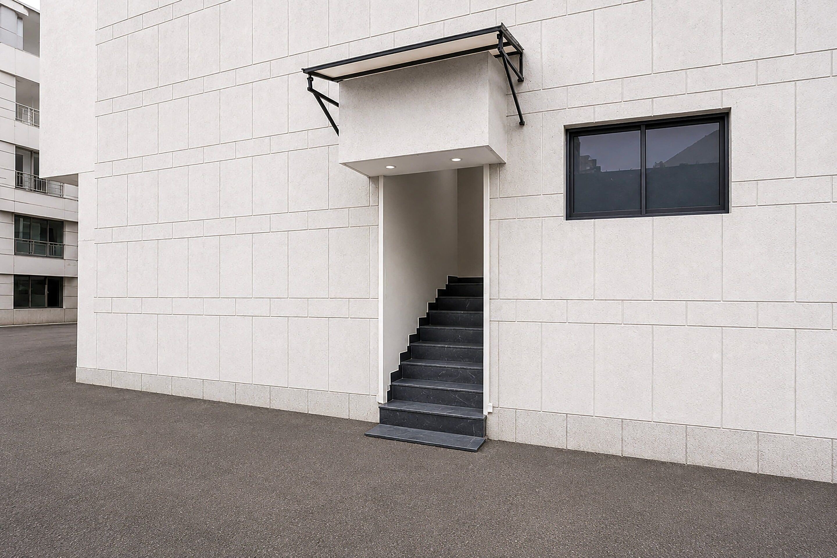 A modern building with a staircase leading to an entrance.