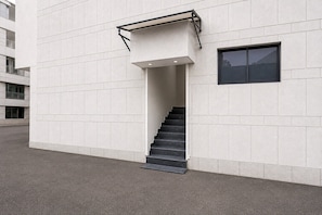 A modern building with a staircase leading to an entrance.
