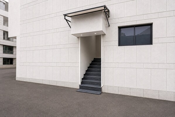 A modern building with a staircase leading to an entrance.