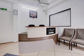 A reception area with a reception desk, a framed photograph on the wall, and a large screen.